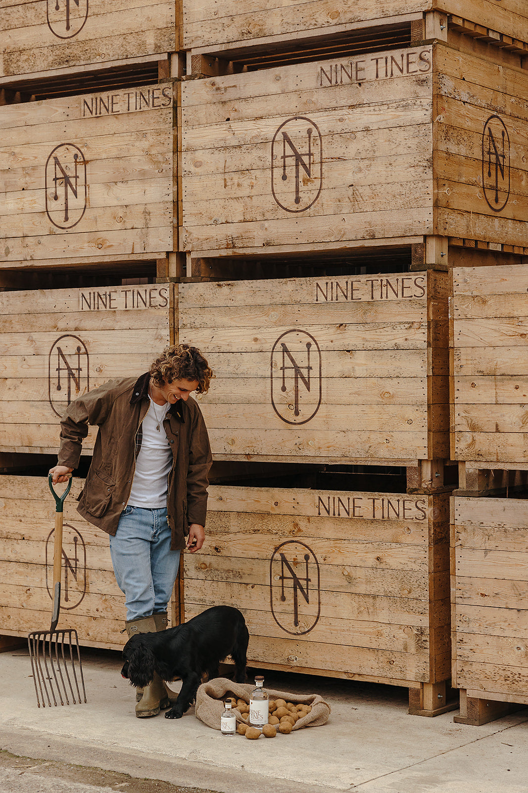 Farmer with dog and vodka in front of potato crates