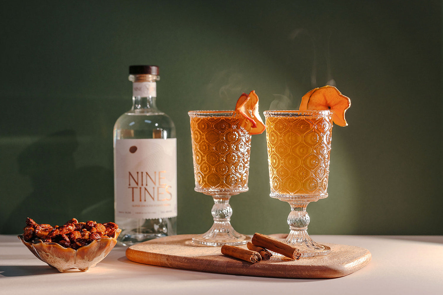 Nine Tines Mulled Tines cocktail with apple slices and cinnamon stick garnish