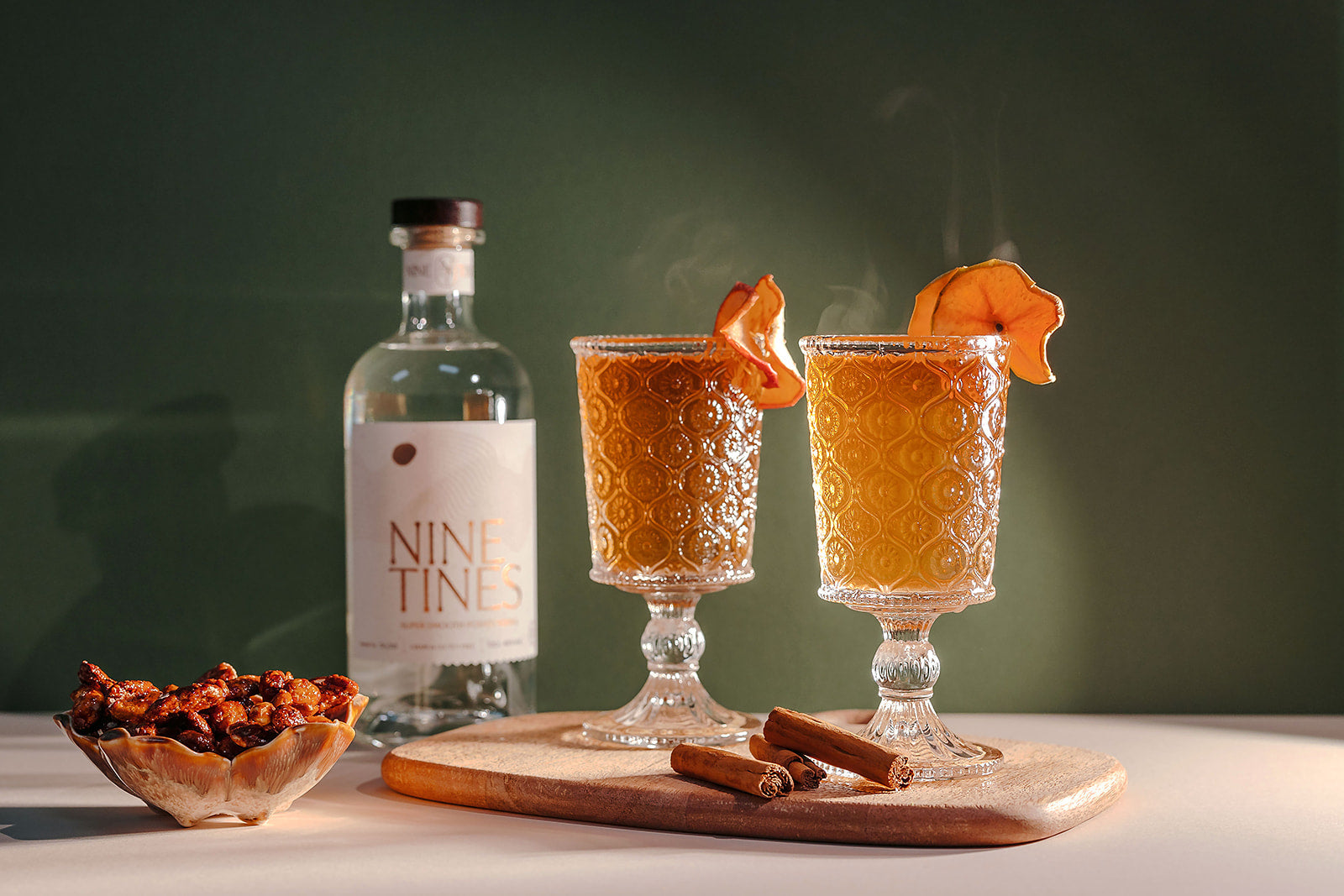 Nine Tines Mulled Tines cocktail with apple slices and cinnamon stick garnish