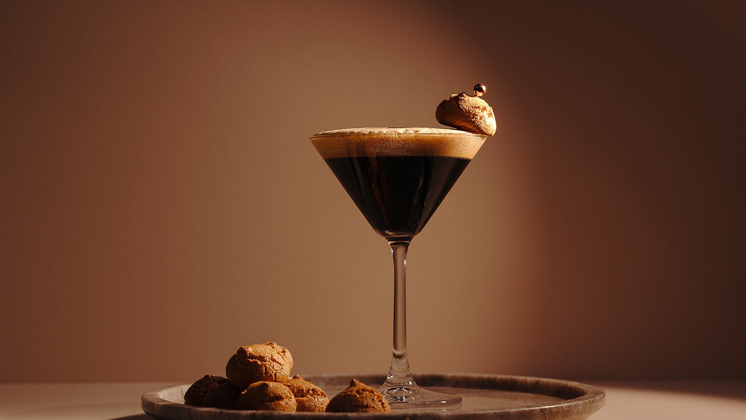 Amaretto Espresso Martini made with Nine Tines Potato Vodka topped with coffee foam and amaretto biscuit garnish