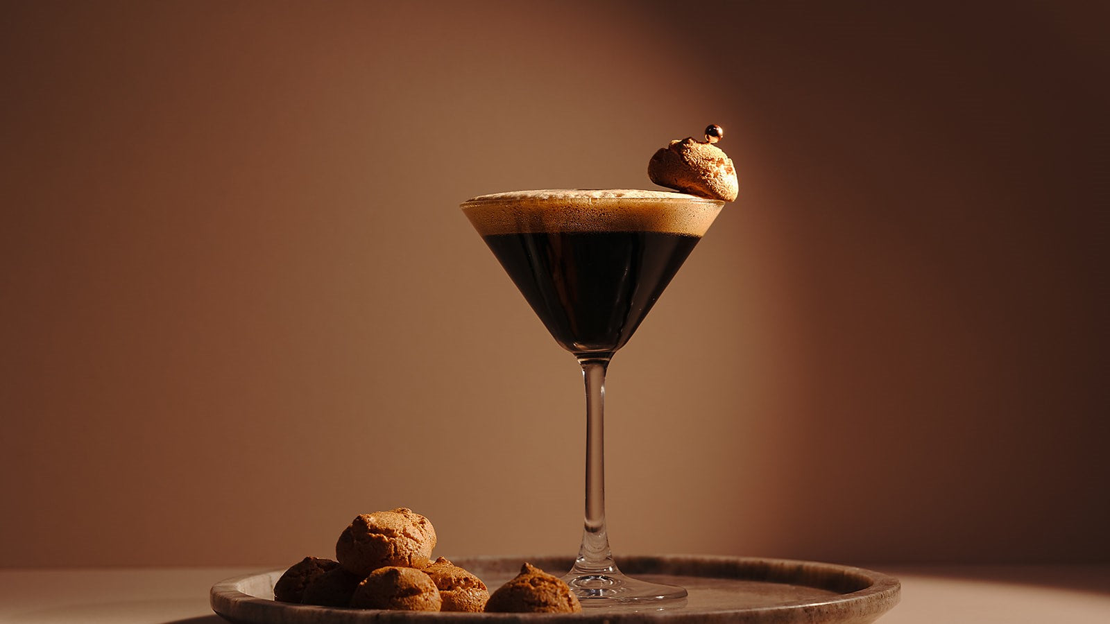 Amaretto Espresso Martini made with Nine Tines Potato Vodka topped with coffee foam and amaretto biscuit garnish