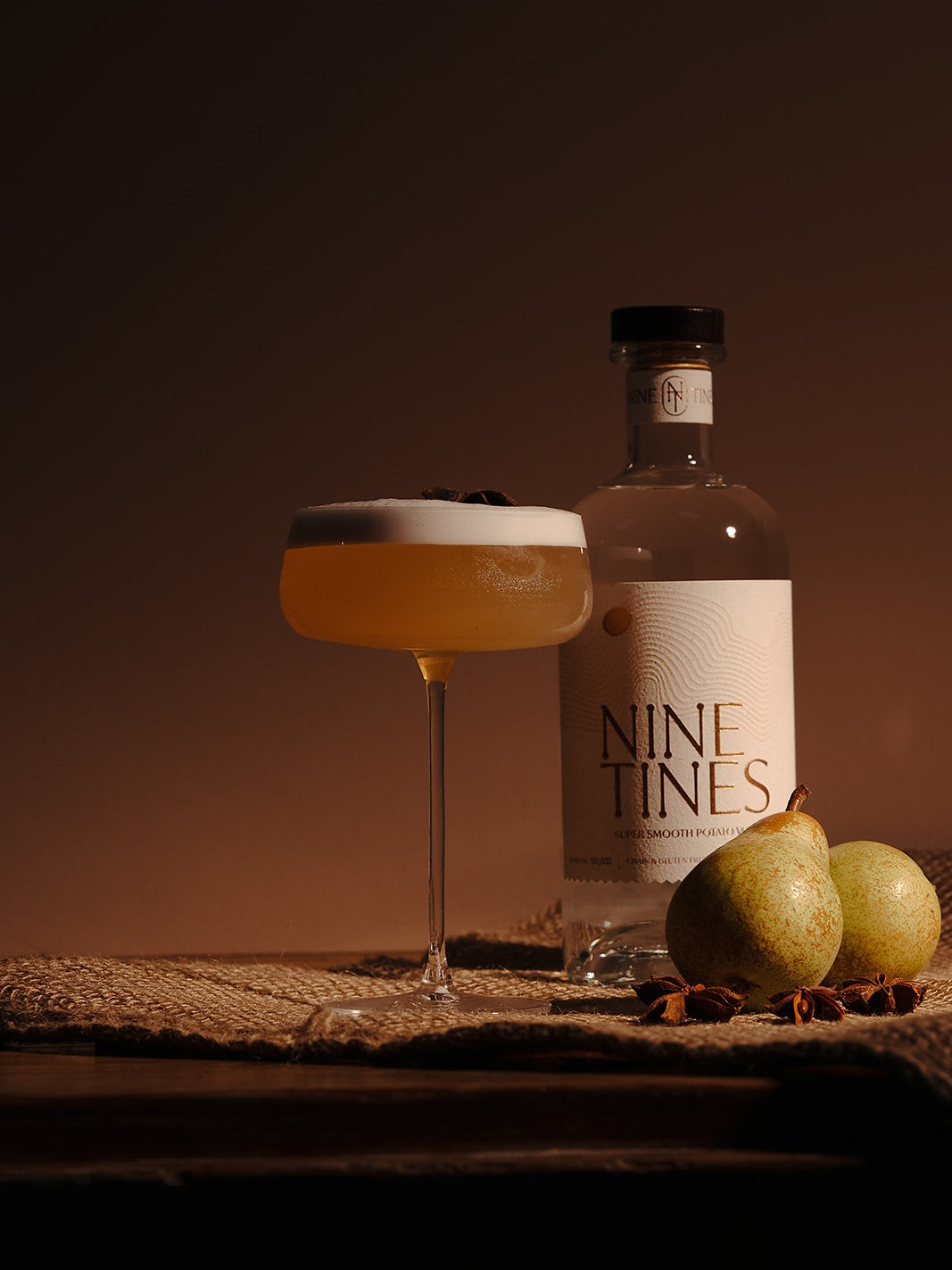 Nine Tines Spiced Pear Collins with star anise garnish in coupe glass with foam top