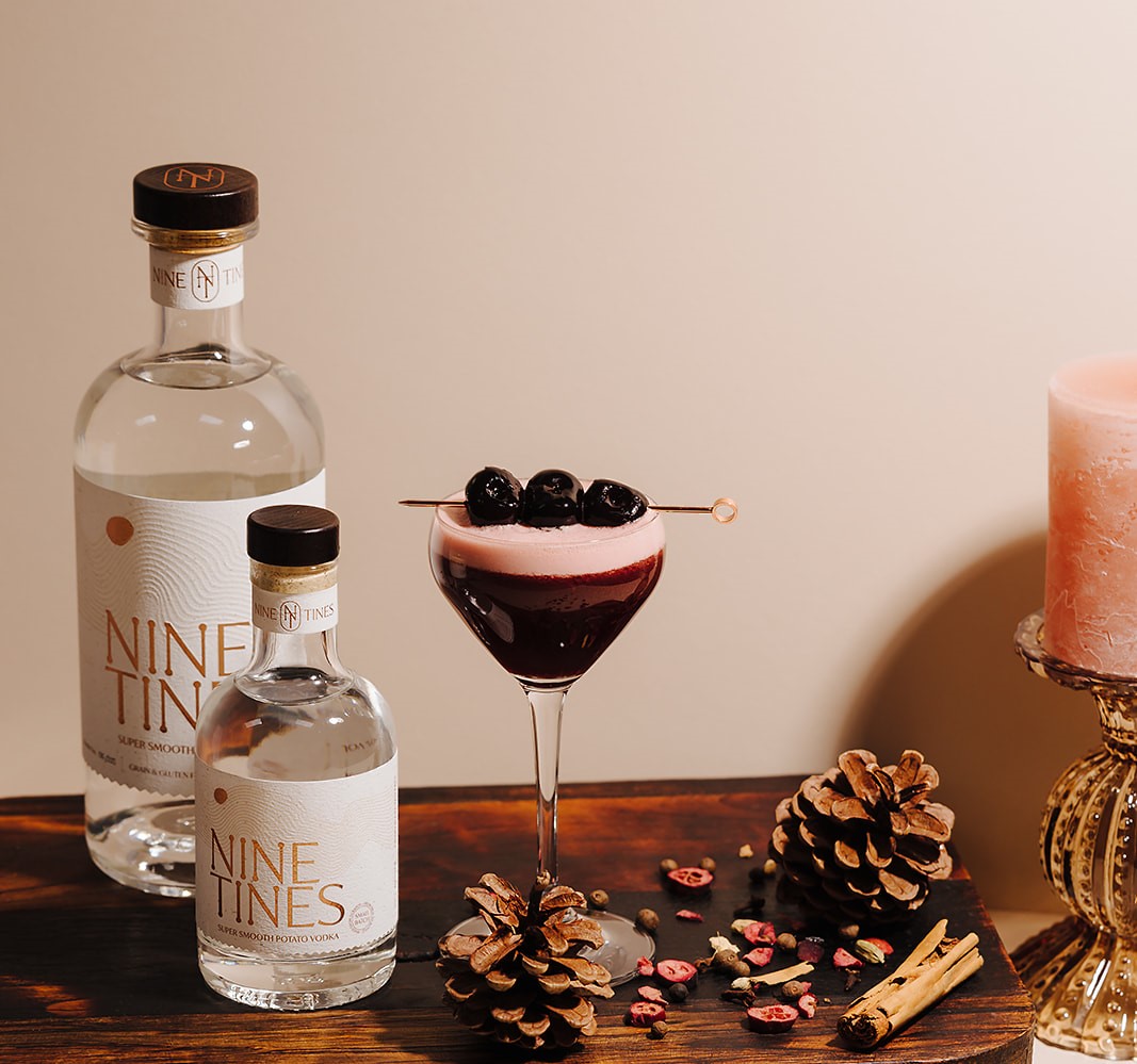Nine Tines Ruby Sour cocktail with cherry garnish and foam top in sour glass